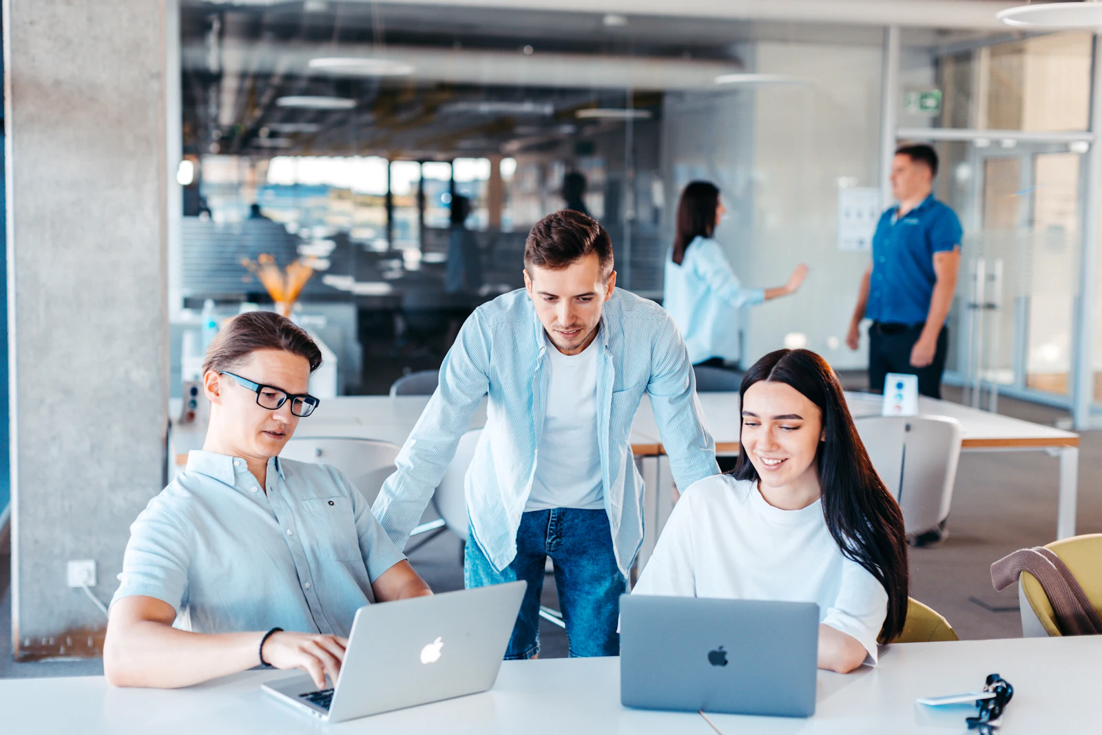 Atelier de formation à l'IA : un formateur accompagne deux participants sur leurs ordinateurs portables